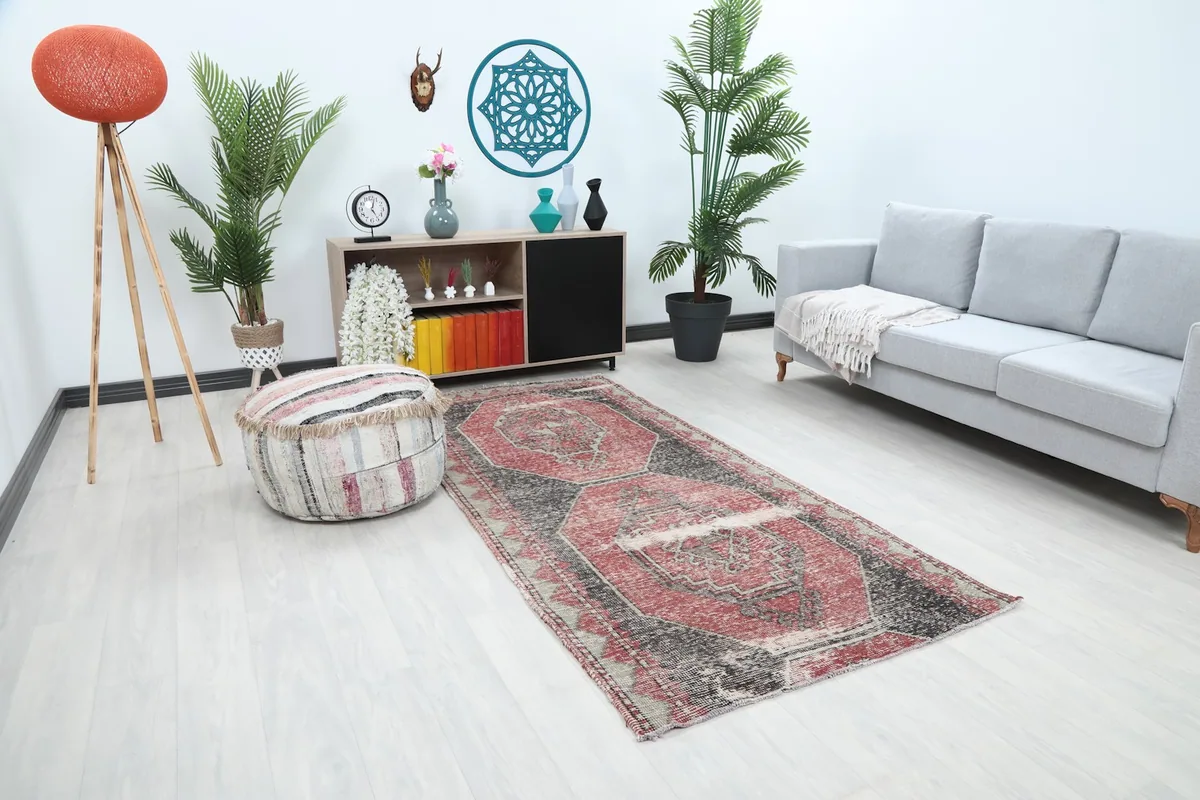 Angle view of the red and charcoal runner in a room with a sofa and decor.