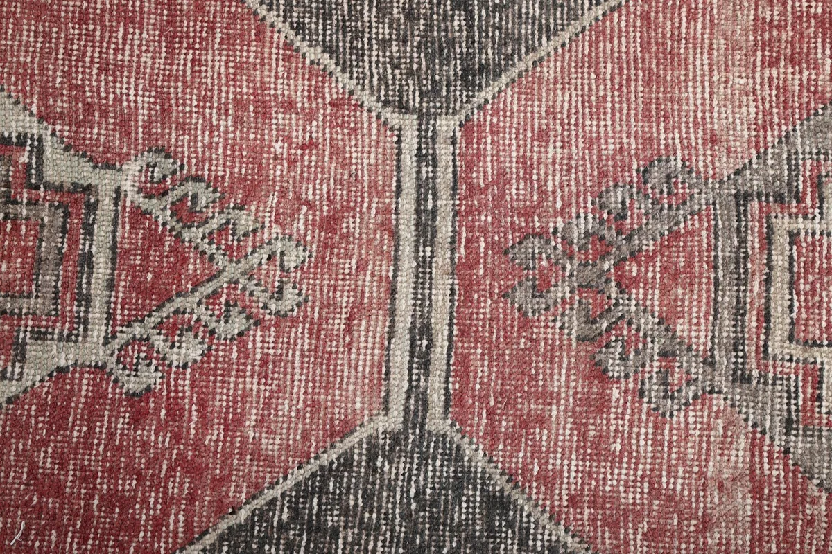 Close-up of the central geometric designs and color variation on the rug's surface.
