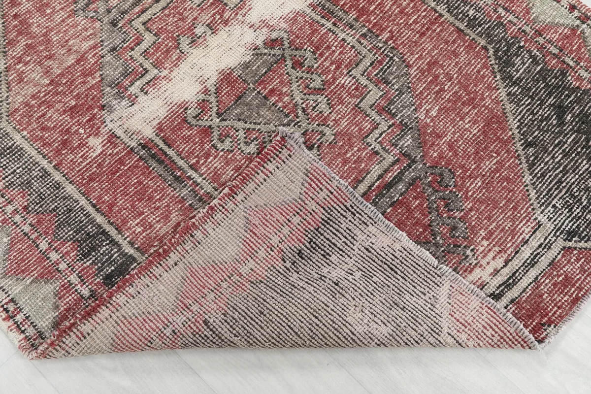 Folded corner of the rug, revealing the wool pile and cotton foundation.