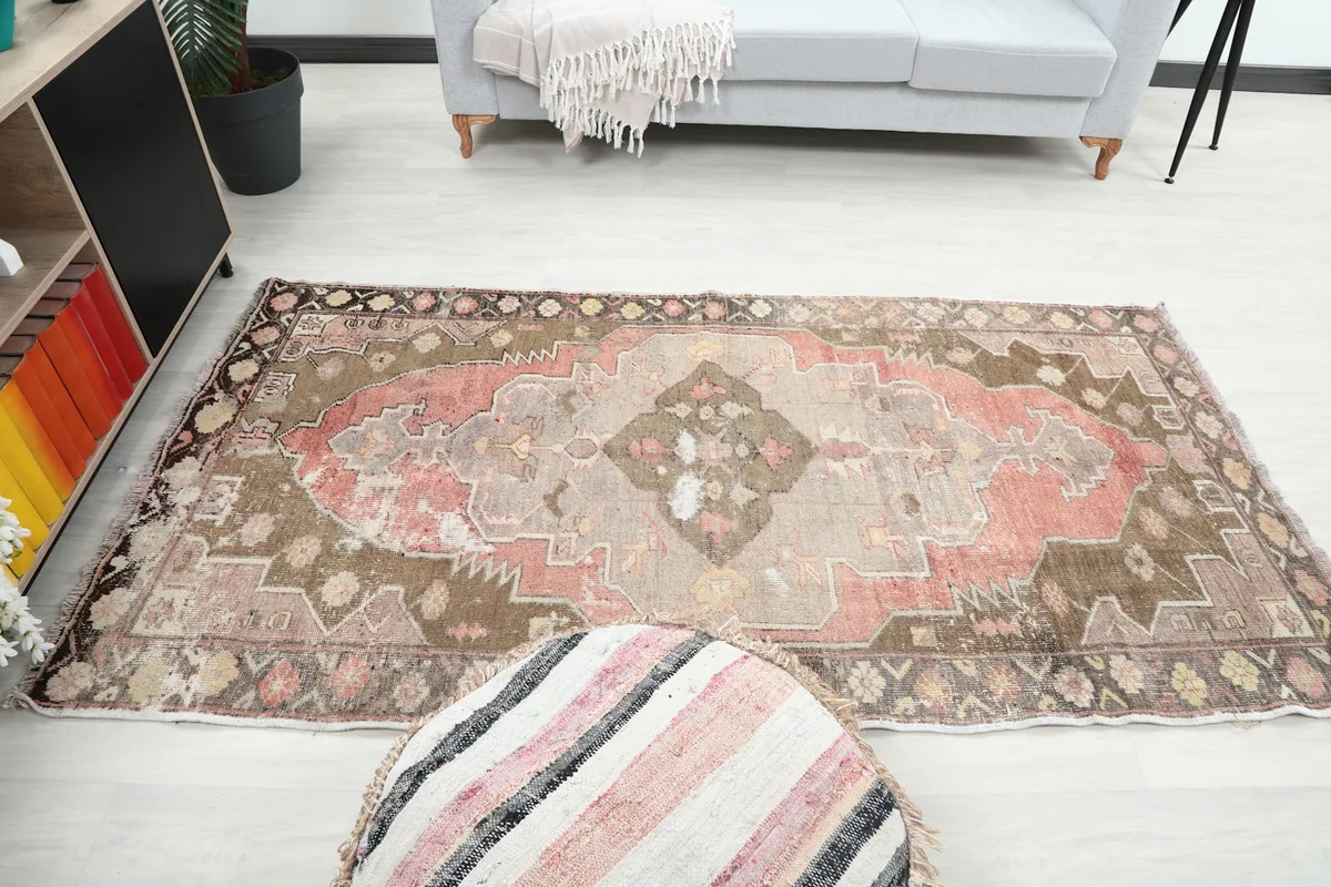 Full room view of the rug, showing it centered in a living space with a sofa and ottoman.