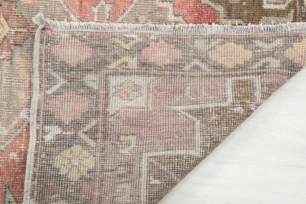 Close-up of the rug's fringe and edge, showing the hand-knotted construction and texture.