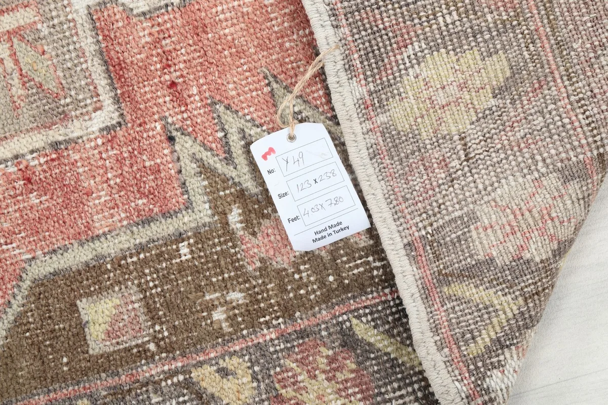 Folded corner of the rug with the product tag visible, displaying size and material information.
