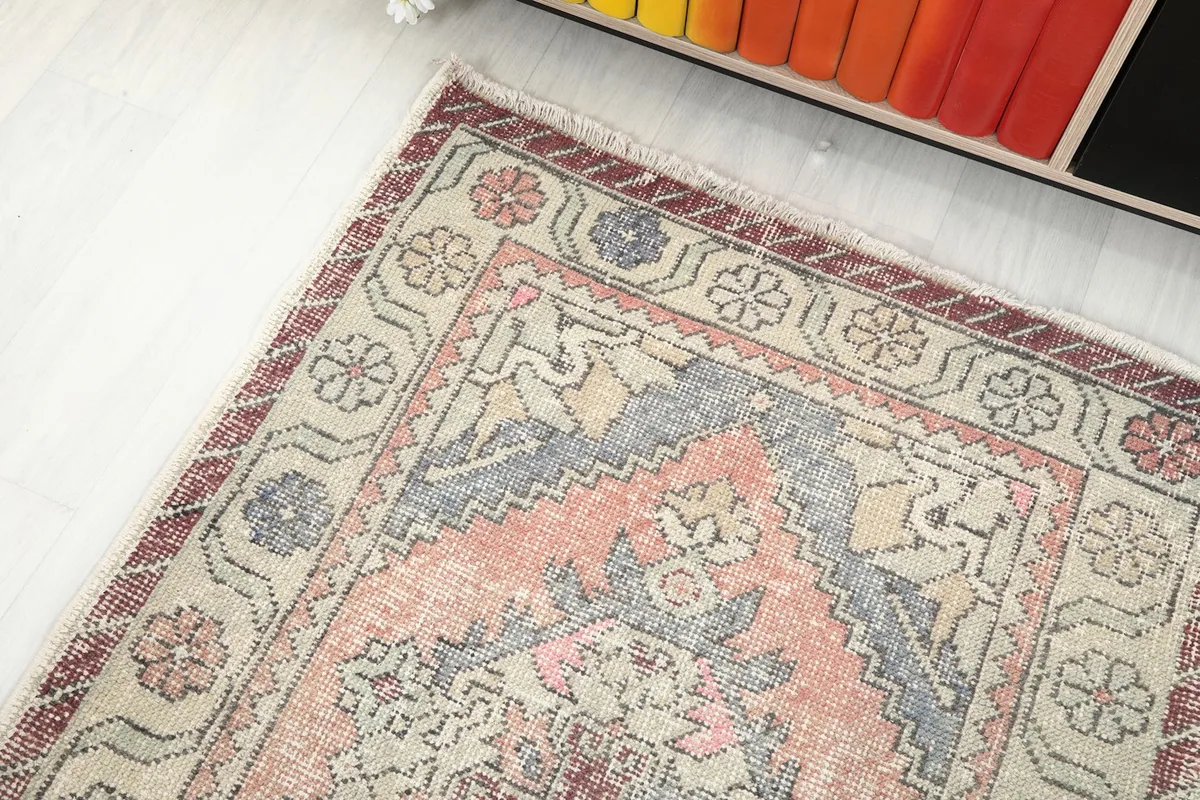 Angle view of the rug's end, showing the intricate geometric and floral details near the border.