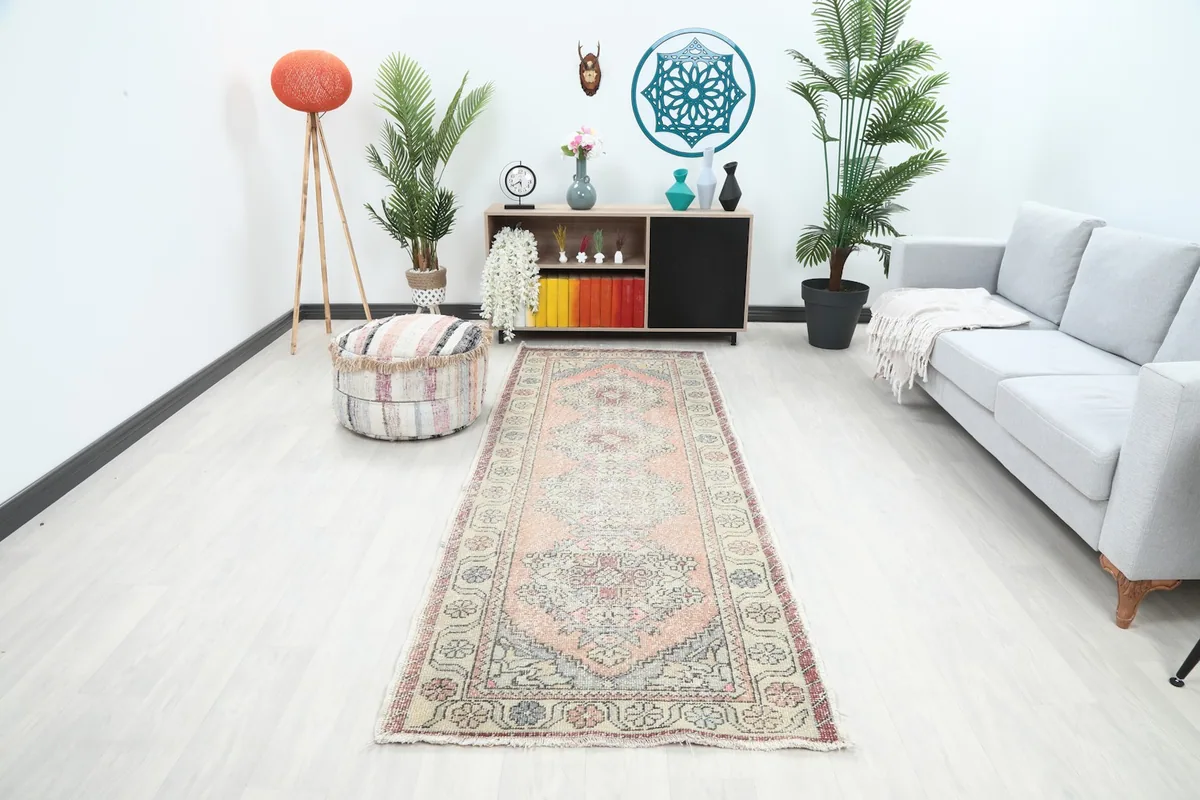 Rust geometric Anatolian runner rug displayed in a bright modern hallway with furniture.