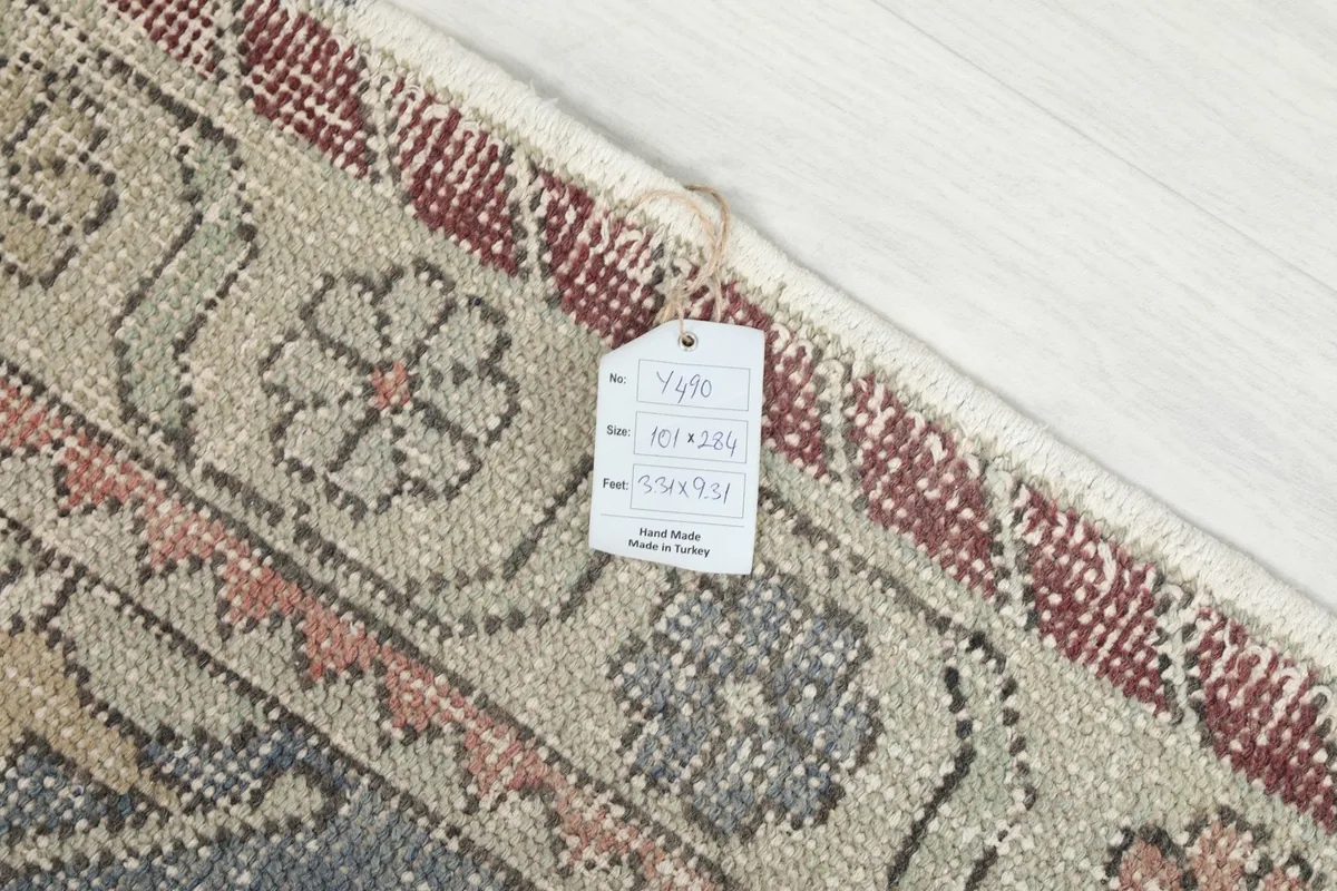 Detail of the rug's edge with a product tag showing its dimensions and origin.