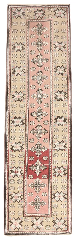 Full overhead view of the beige and pink vintage Anatolian runner rug on a white background.