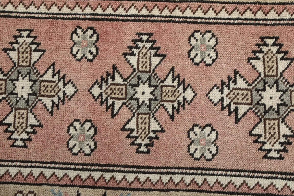 Close-up of the intricate geometric motifs in the central pink panel of the runner.
