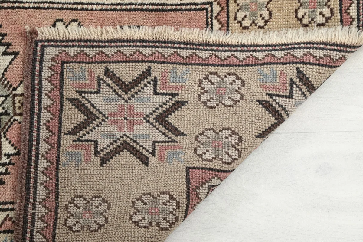 Detail of the rug's back and fringe, showing the hand-knotted construction.