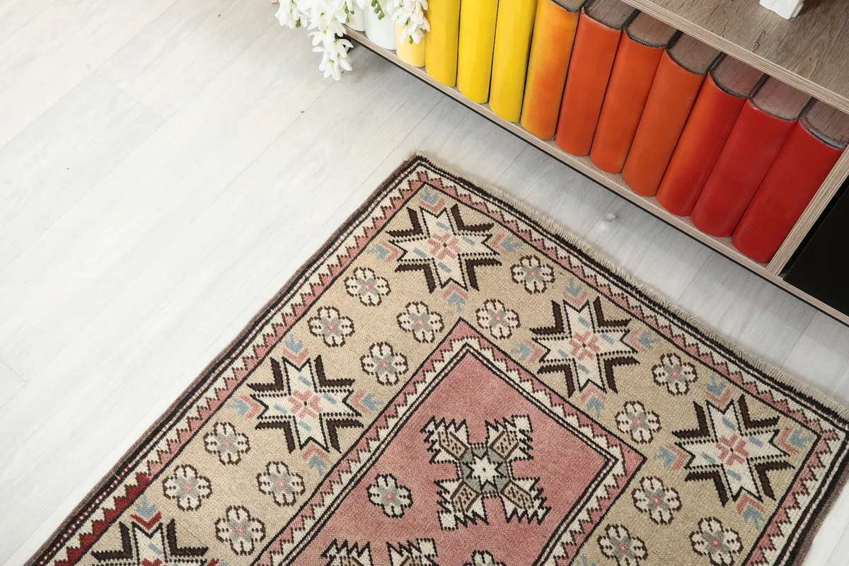 Overhead view focusing on one end of the runner rug, showing the beige and pink design.