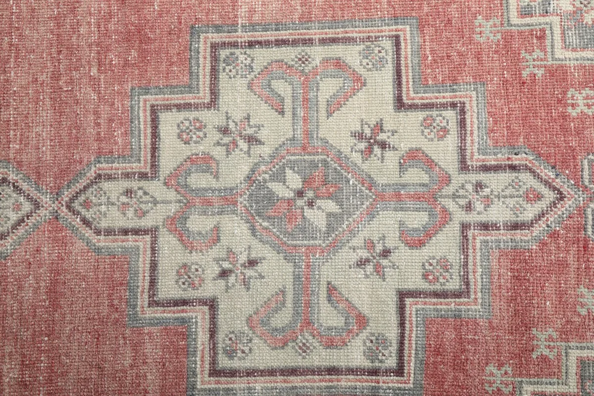 Detailed view of the central geometric medallion with ivory and gray tones