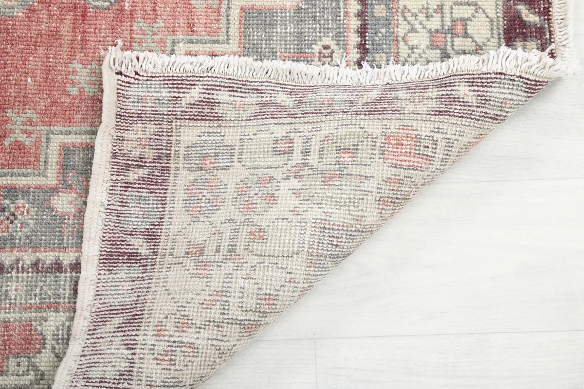 Underside of the hand-knotted wool rug, revealing the cotton foundation