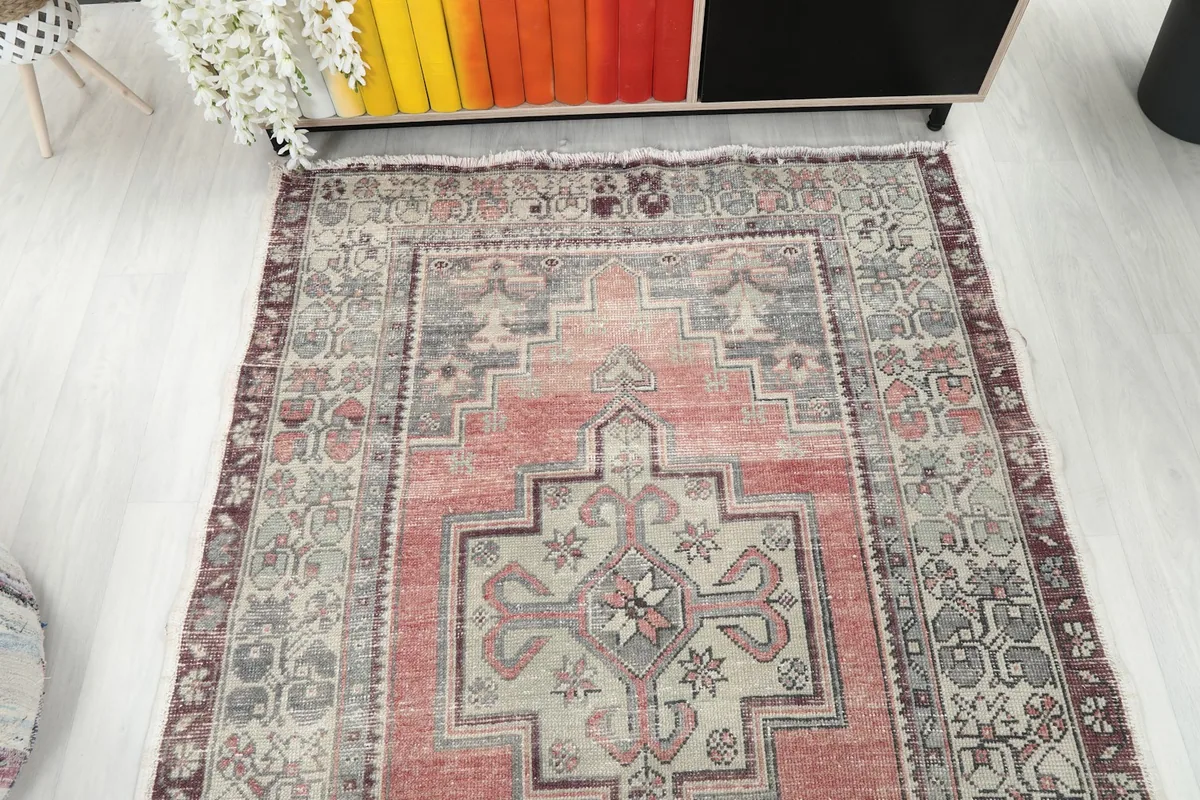 Overhead view showing the full length and design of the rose and gray rug
