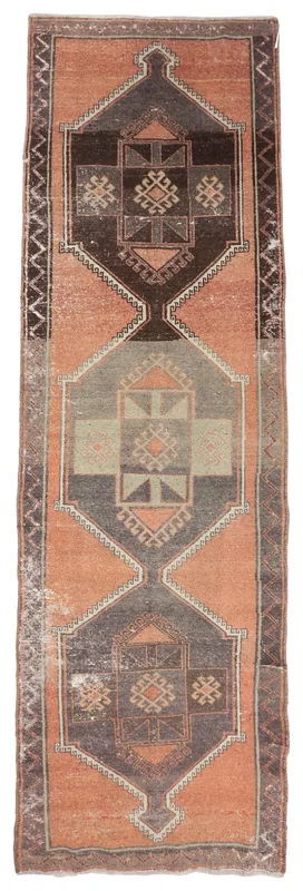 Full overhead view of the vintage Anatolian runner rug with rust field and gray geometric motifs.