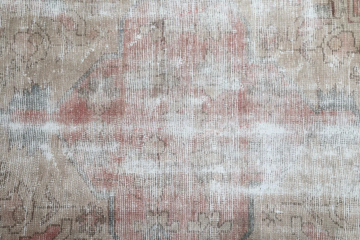 Detailed view of the central field, showing the blend of rose, beige, and geometric motifs