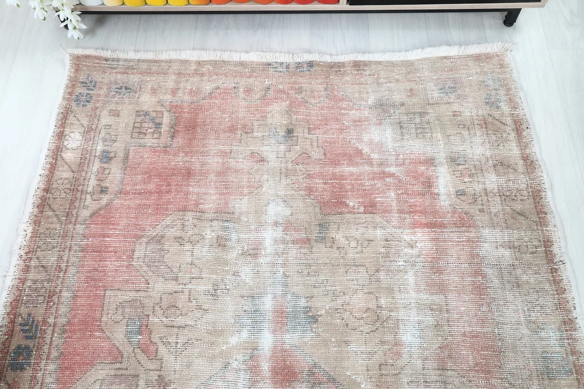Overhead shot of the rug's top half, emphasizing the faded rose tones and beige patterns