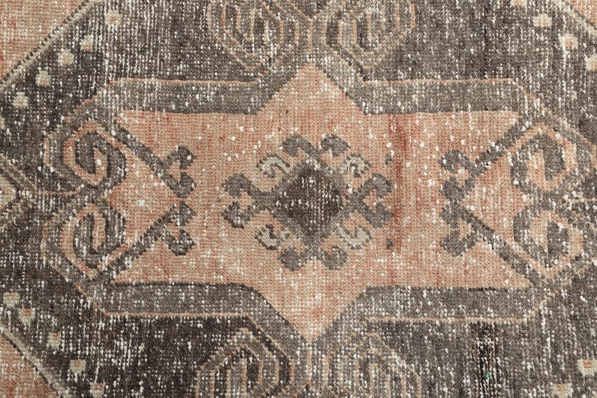 Detailed shot of the central medallion-like motif with its faded wool pile texture