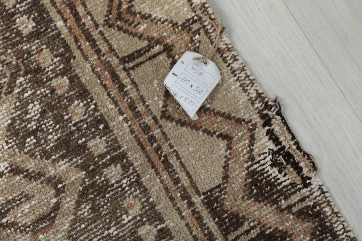 Corner of the rug with a size tag, showing the 110 x 340 cm dimensions