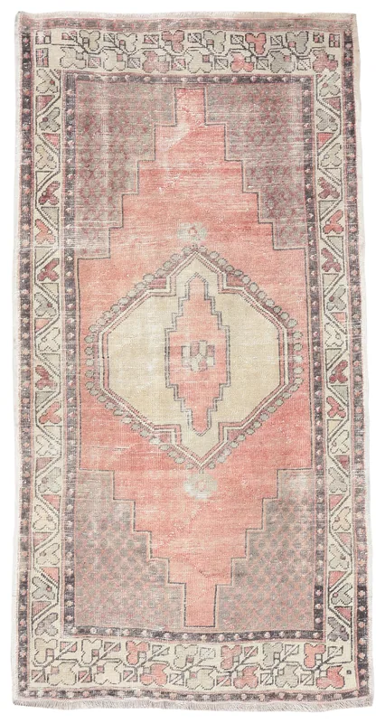 Full overhead view of the vintage rose and beige geometric Anatolian rug
