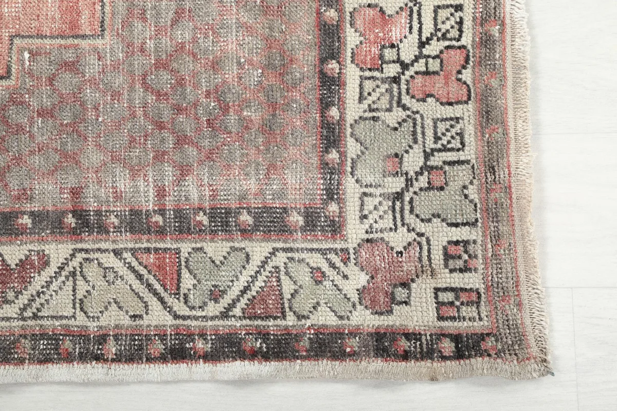 Detail of the rug's corner showing the geometric border patterns