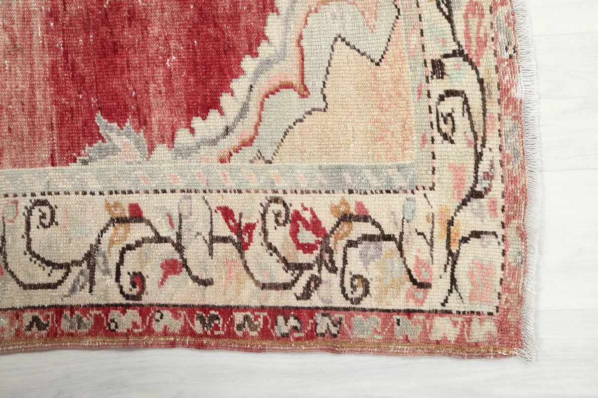 Detailed view of the Red Medallion Anatolian Area Rug's floral border with beige, gray, and red motifs.