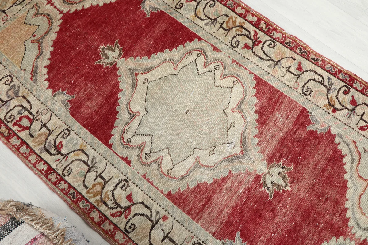 Overhead detail of the Red Medallion Anatolian Area Rug's central beige medallion and surrounding red field.