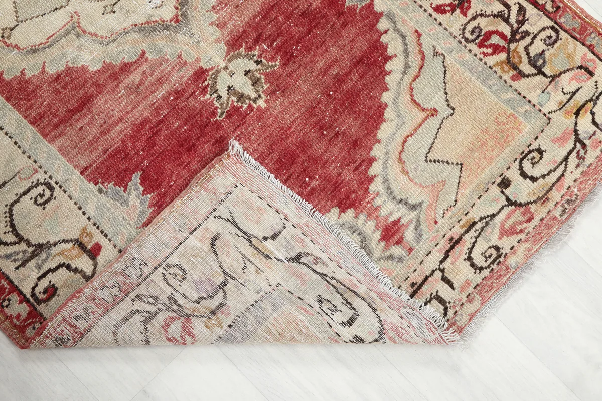 Corner of the Red Medallion Anatolian Area Rug folded to show the hand-knotted construction and back of the rug.