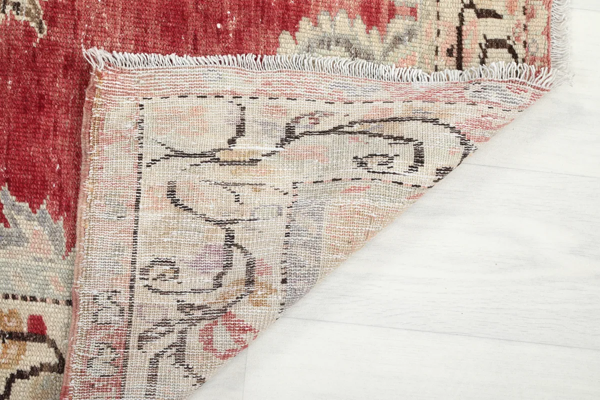 Close-up of the Red Medallion Anatolian Area Rug's corner folded to reveal the cotton foundation and fringe.