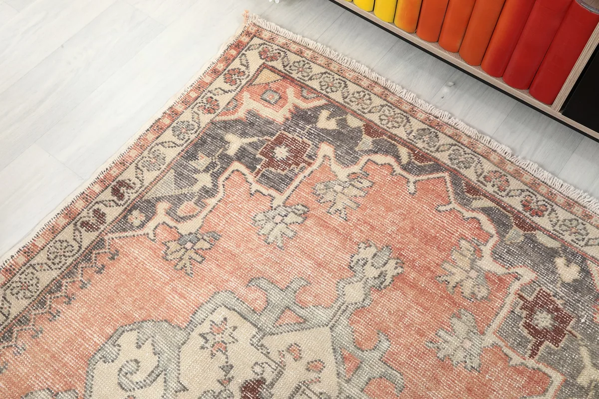 Detail of the rug's outer border with repeating patterns in ivory and gray