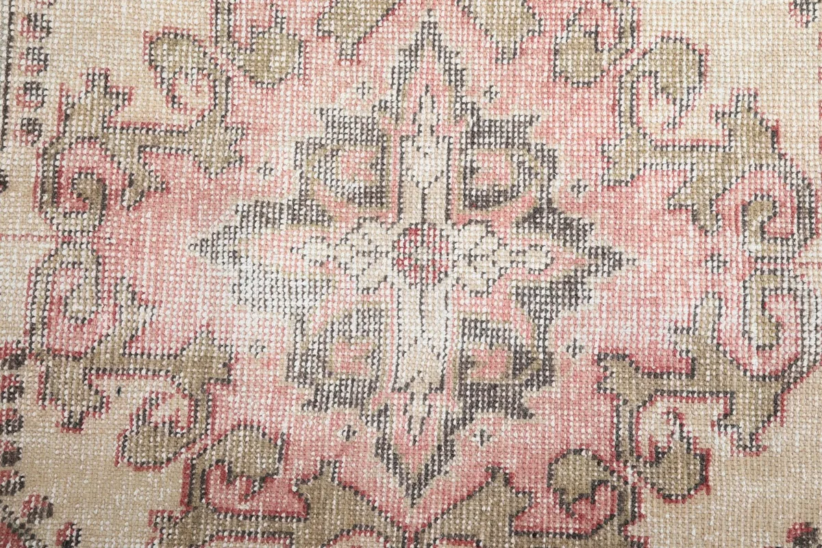Detailed view of the central medallion's faded colors and intricate floral patterns.
