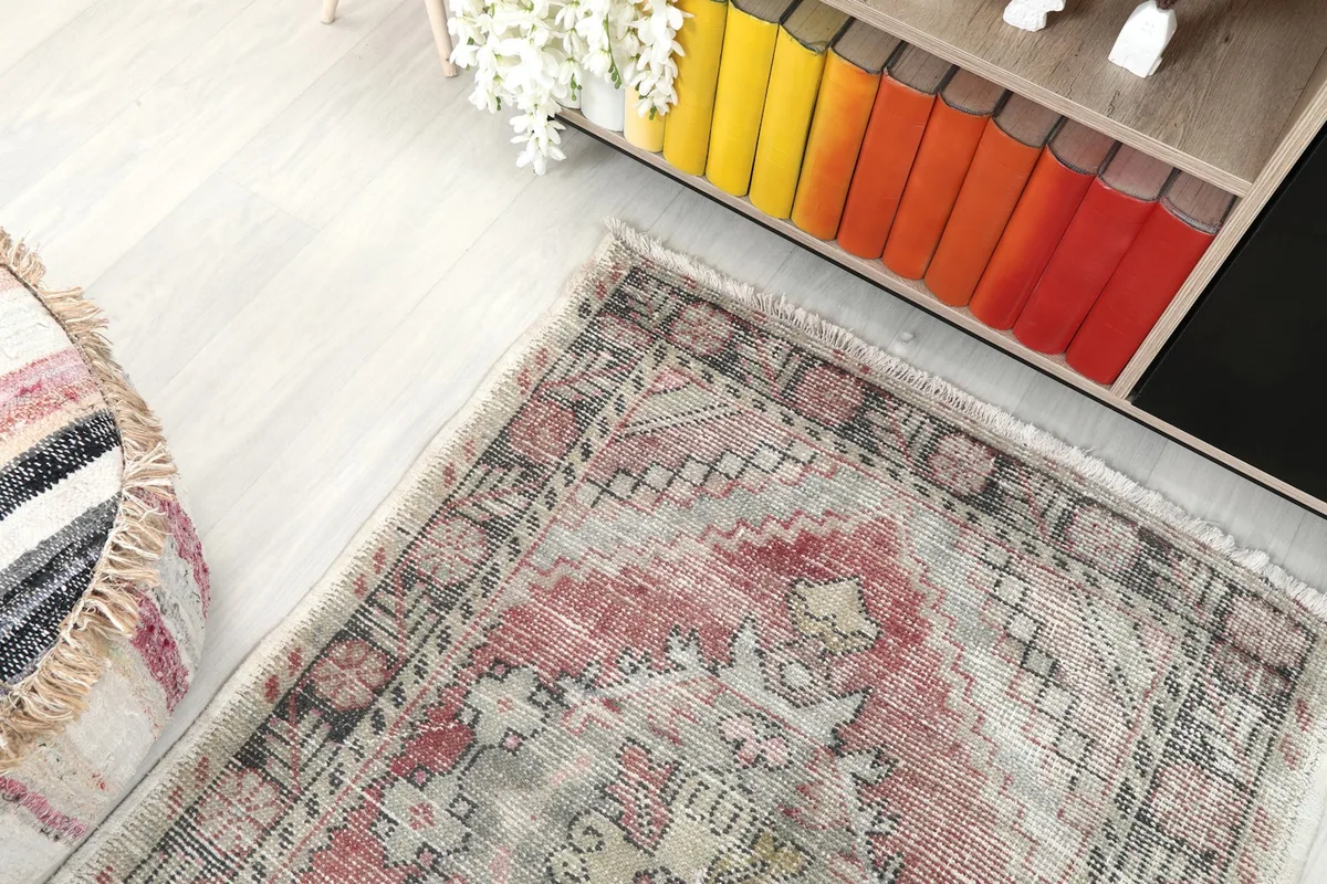 Overhead angle view of the rose and gray rug in a room, showing its full length and patterns from above.