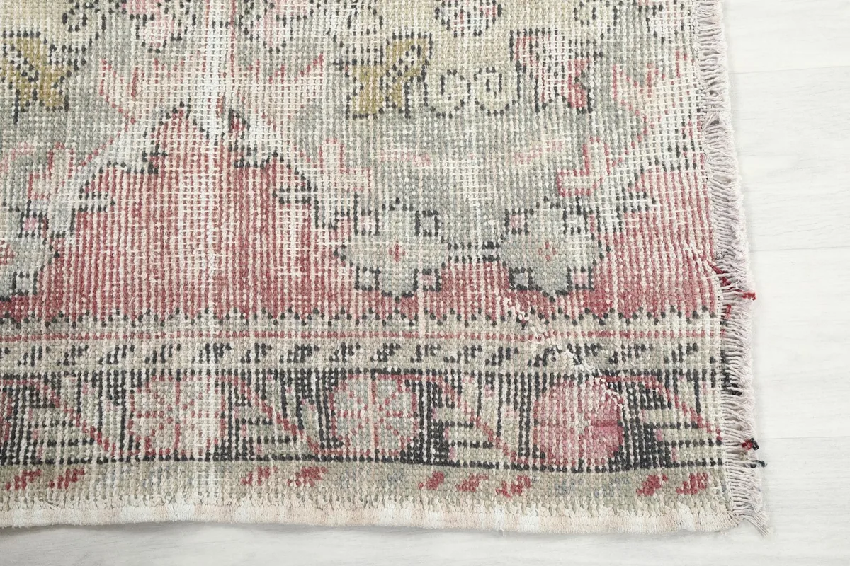 Detailed view of the rug's border and corner, showing the hand-knotted wool pile and cotton foundation.