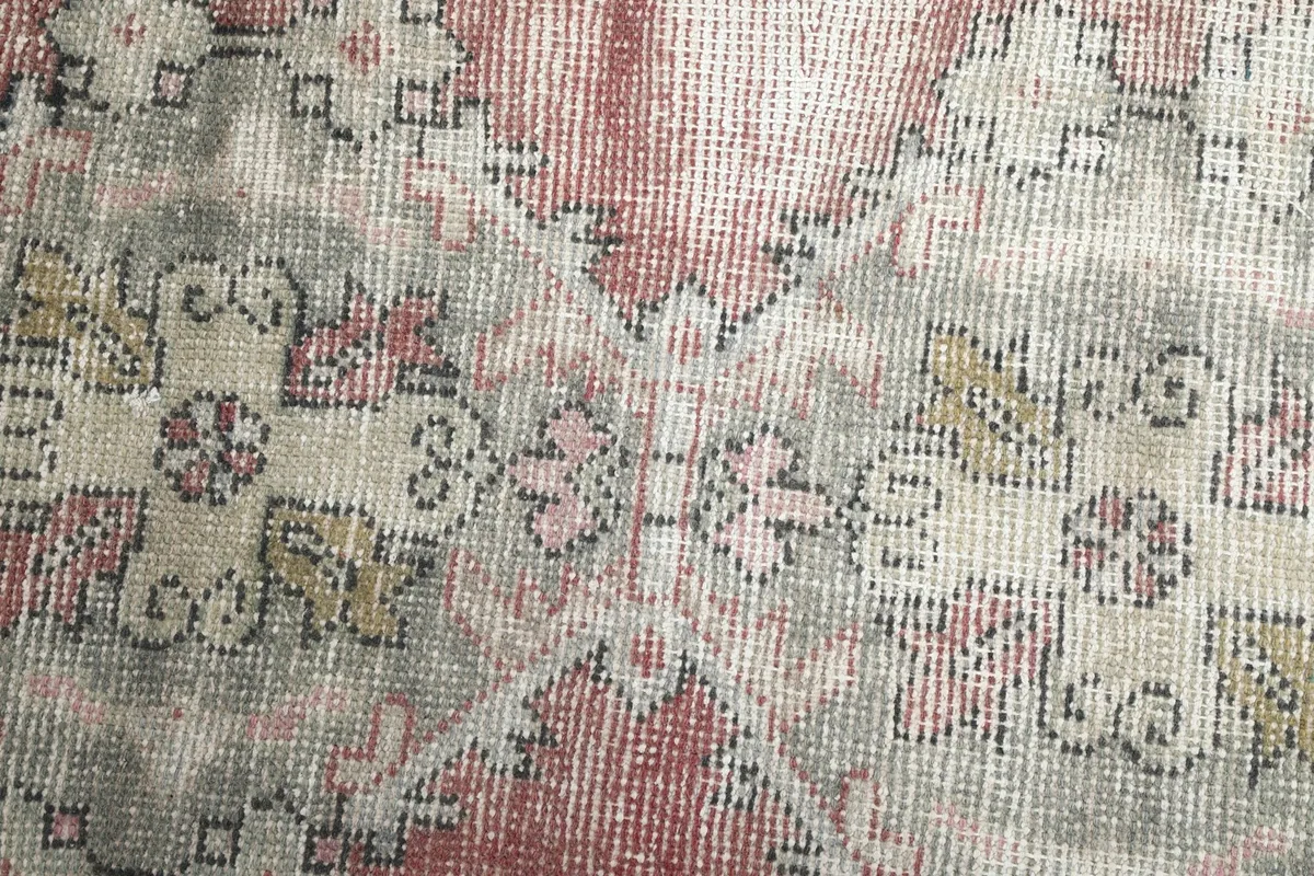 Macro view of the low wool pile, revealing the intricate knotting and color variations of the vintage rug.