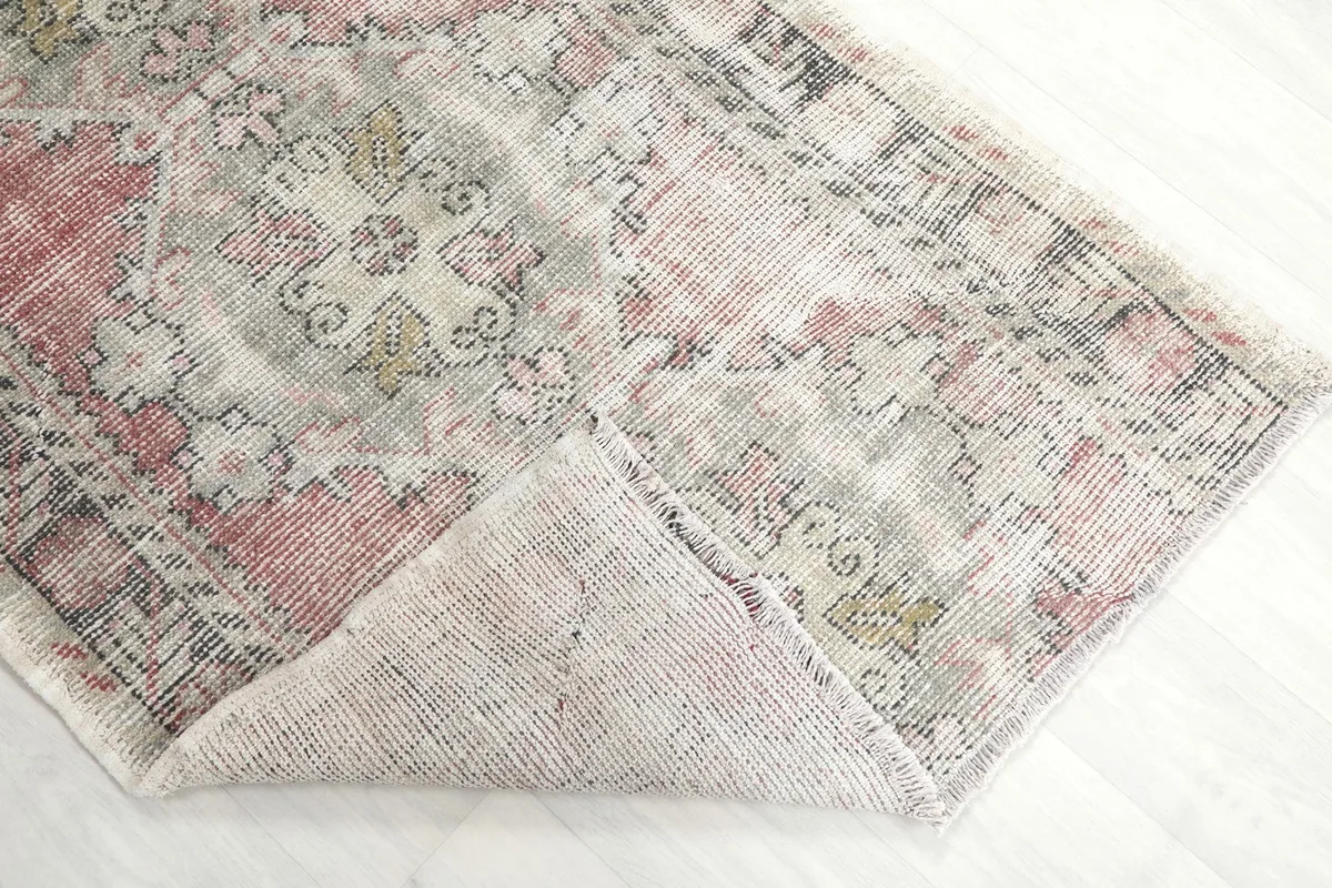 Corner of the rug folded back to show the reverse side of the hand-knotted wool on cotton foundation.