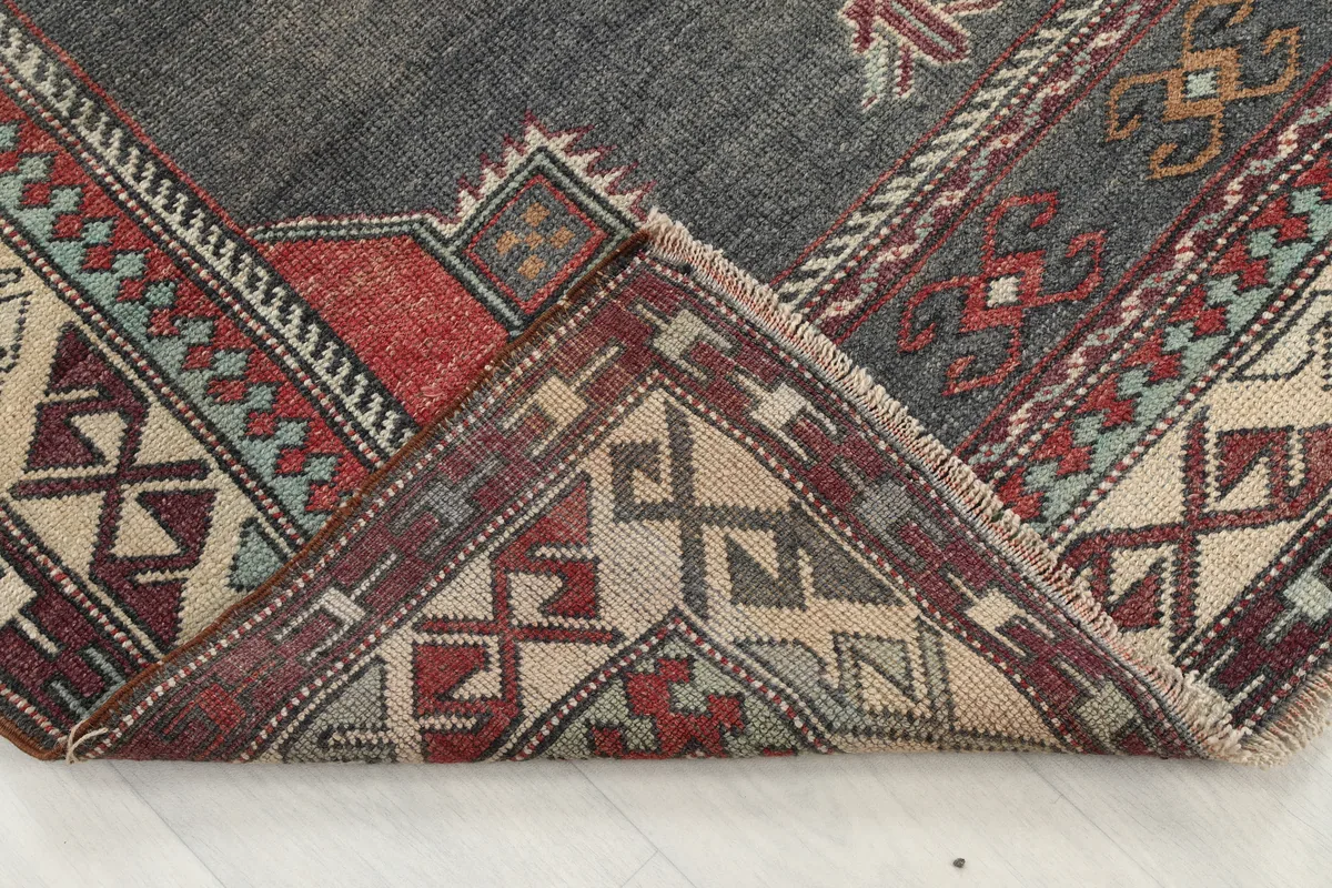 Folded corner of the Red Gray Tribal Medallion Rug, showing the thickness and back of the weave