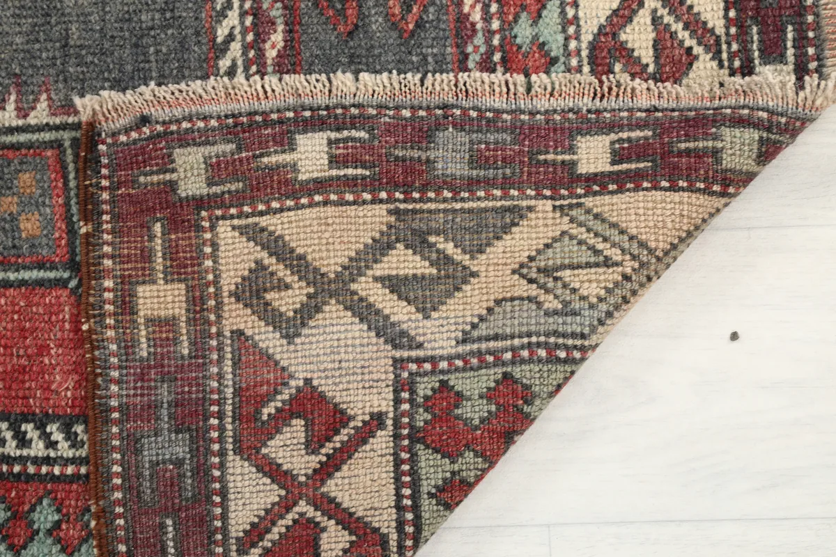 Underside and folded edge of the Red Gray Tribal Medallion Rug, revealing its hand-knotted construction