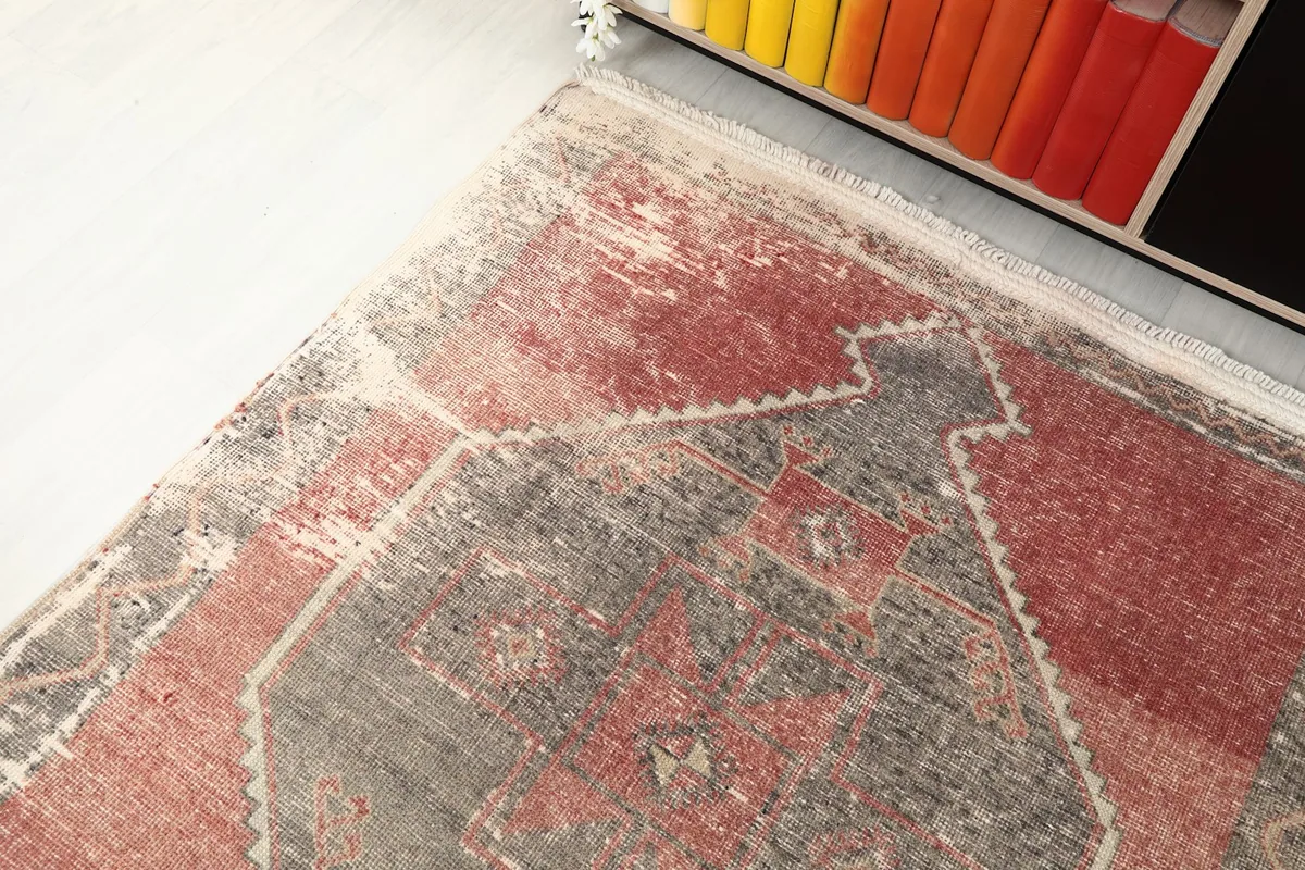 Corner view of the runner rug, showing the blend of rose and charcoal, and the slightly uneven edges.