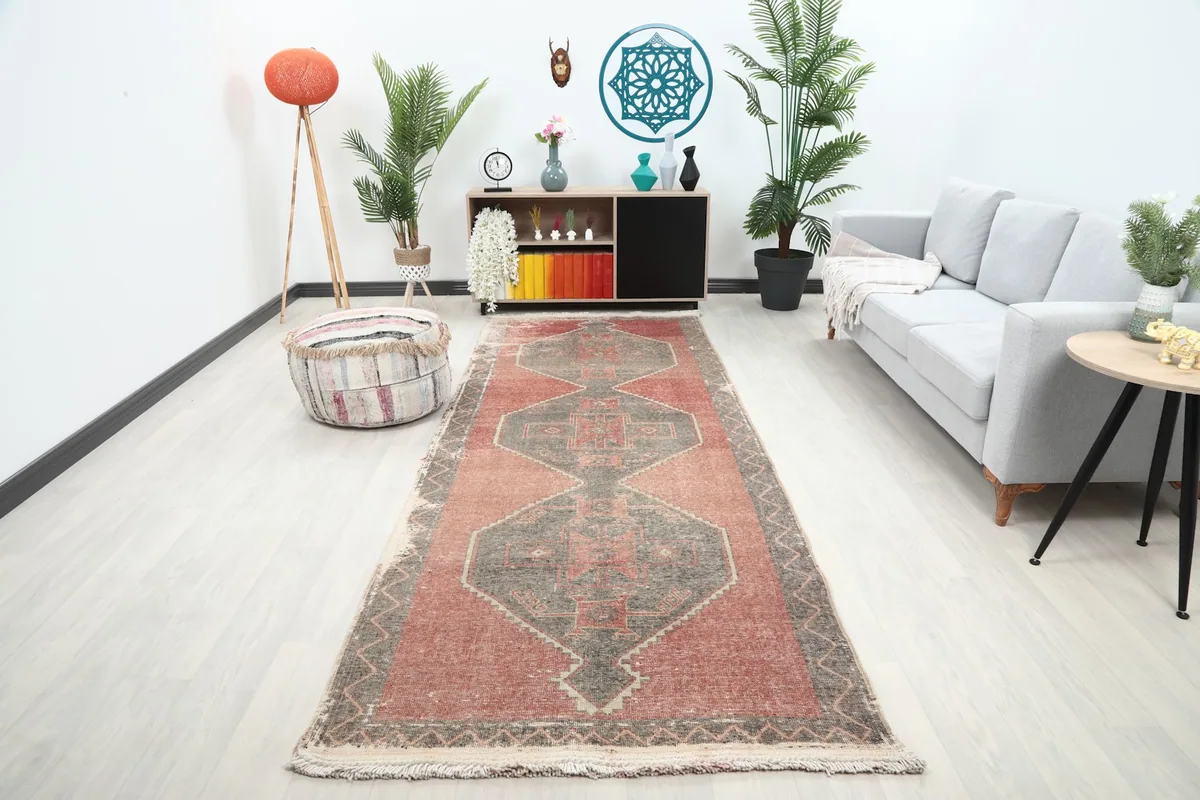 Runner rug displayed in a modern living space with a gray sofa and plants, showing its full length.
