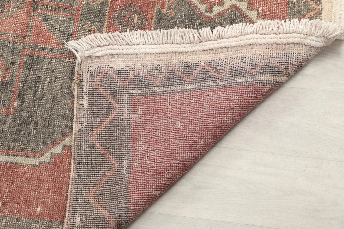 Underside of the rug, revealing the tight knotting of the wool pile and the cotton foundation.