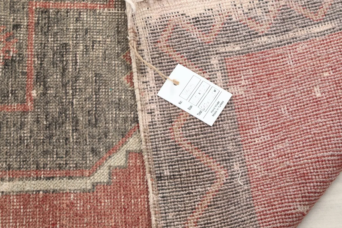 Close-up of the rug's back with a product tag, showing the quality of the hand-knotted construction.