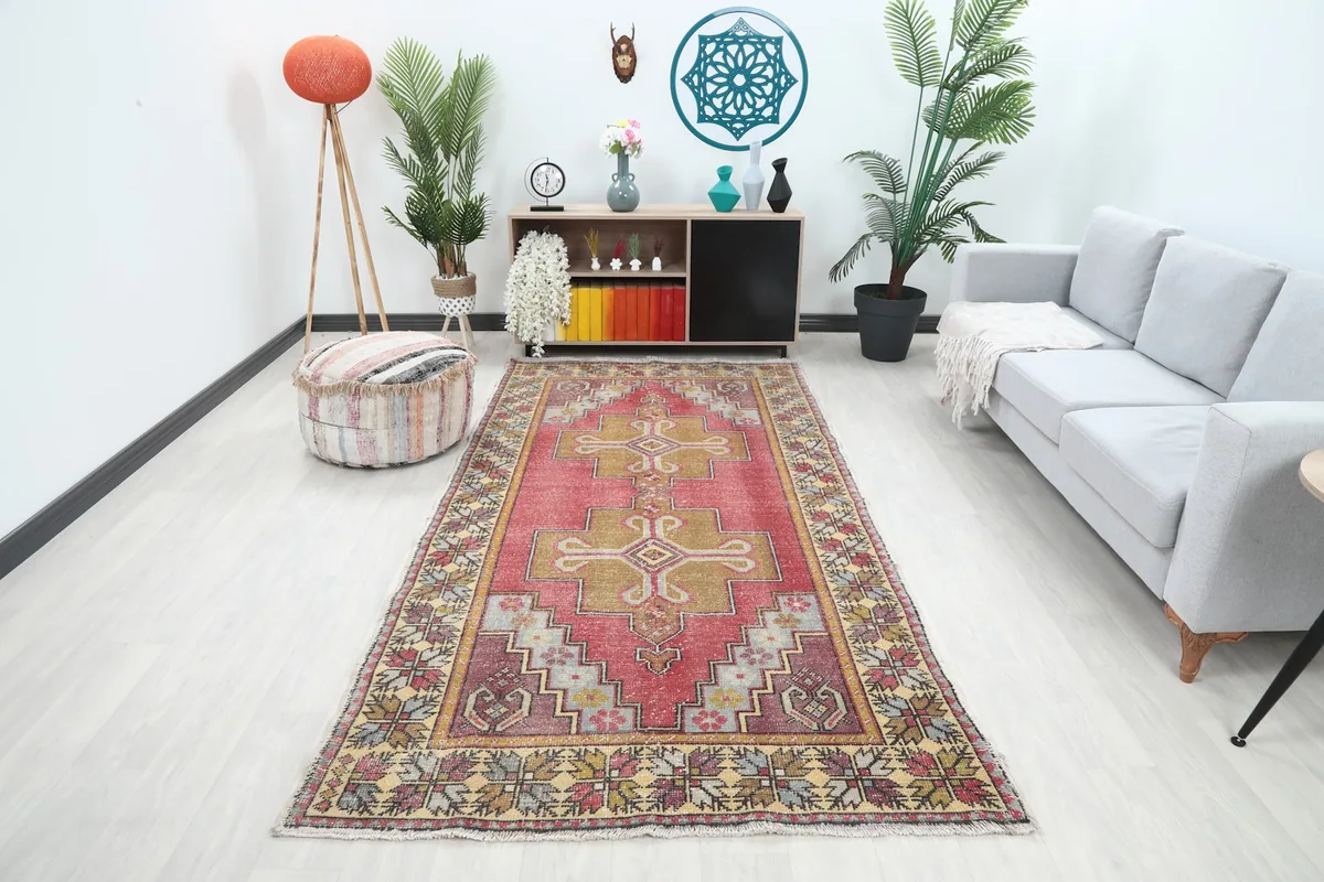Vintage Anatolian rug displayed in a modern living room setting with a sofa and decor