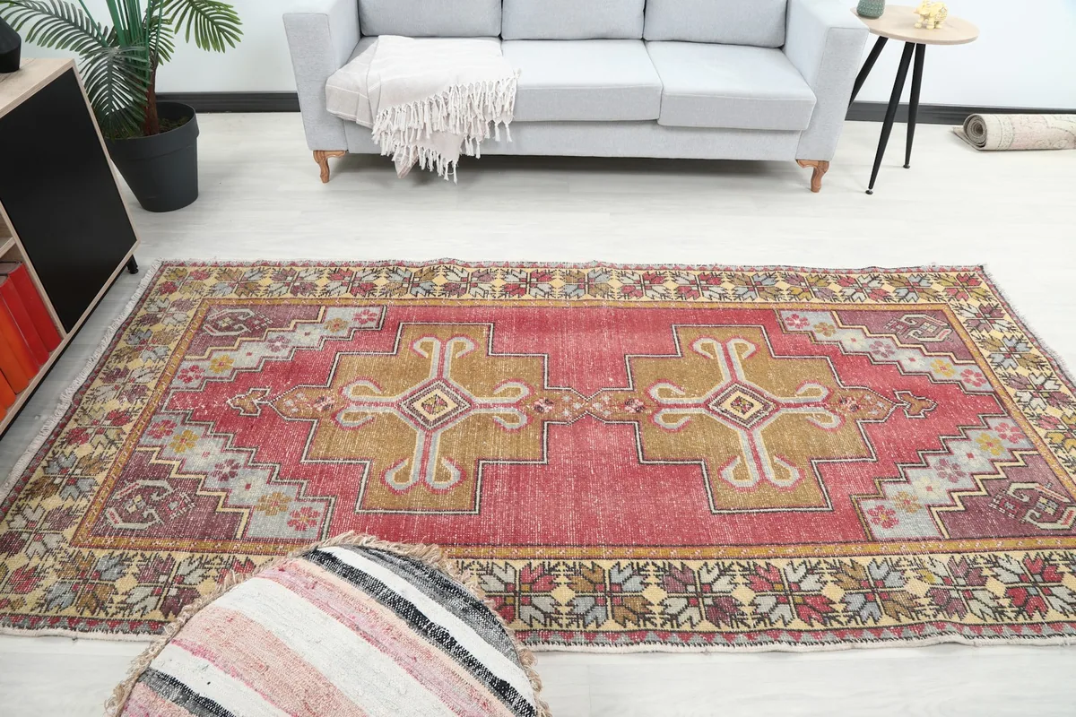 Wide shot of the vintage rug in a living room, providing a sense of its scale