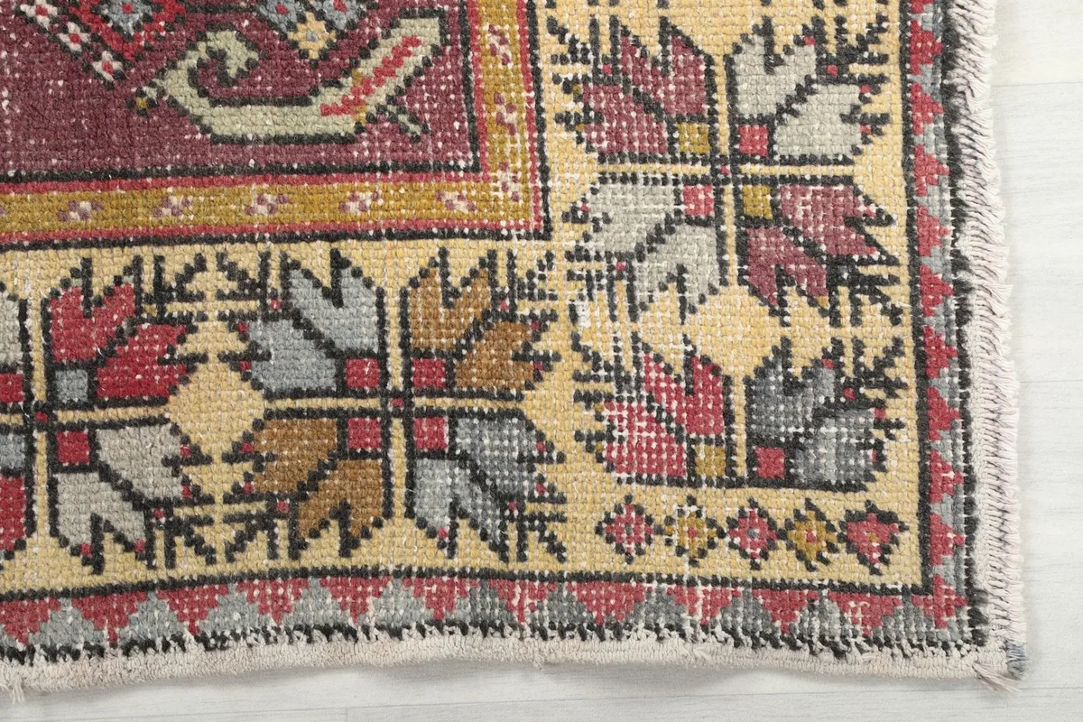Detailed view of the beige border with rose, gray, and gold floral-geometric patterns
