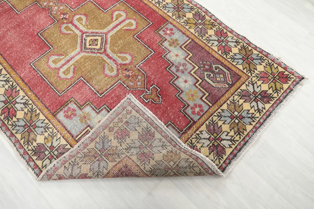 Corner of the rug folded back to reveal the hand-knotted cotton foundation