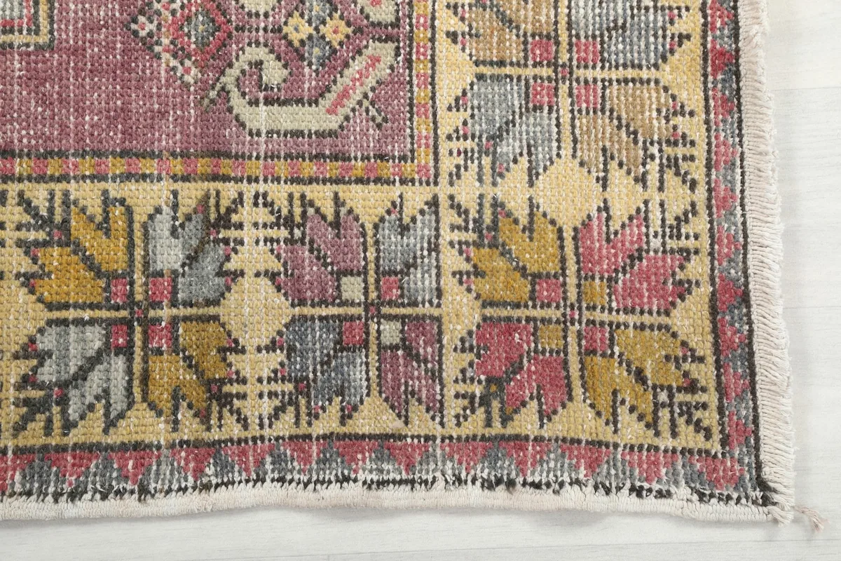 Detailed view of the multicolor tribal border pattern with gray, yellow, and rose tones