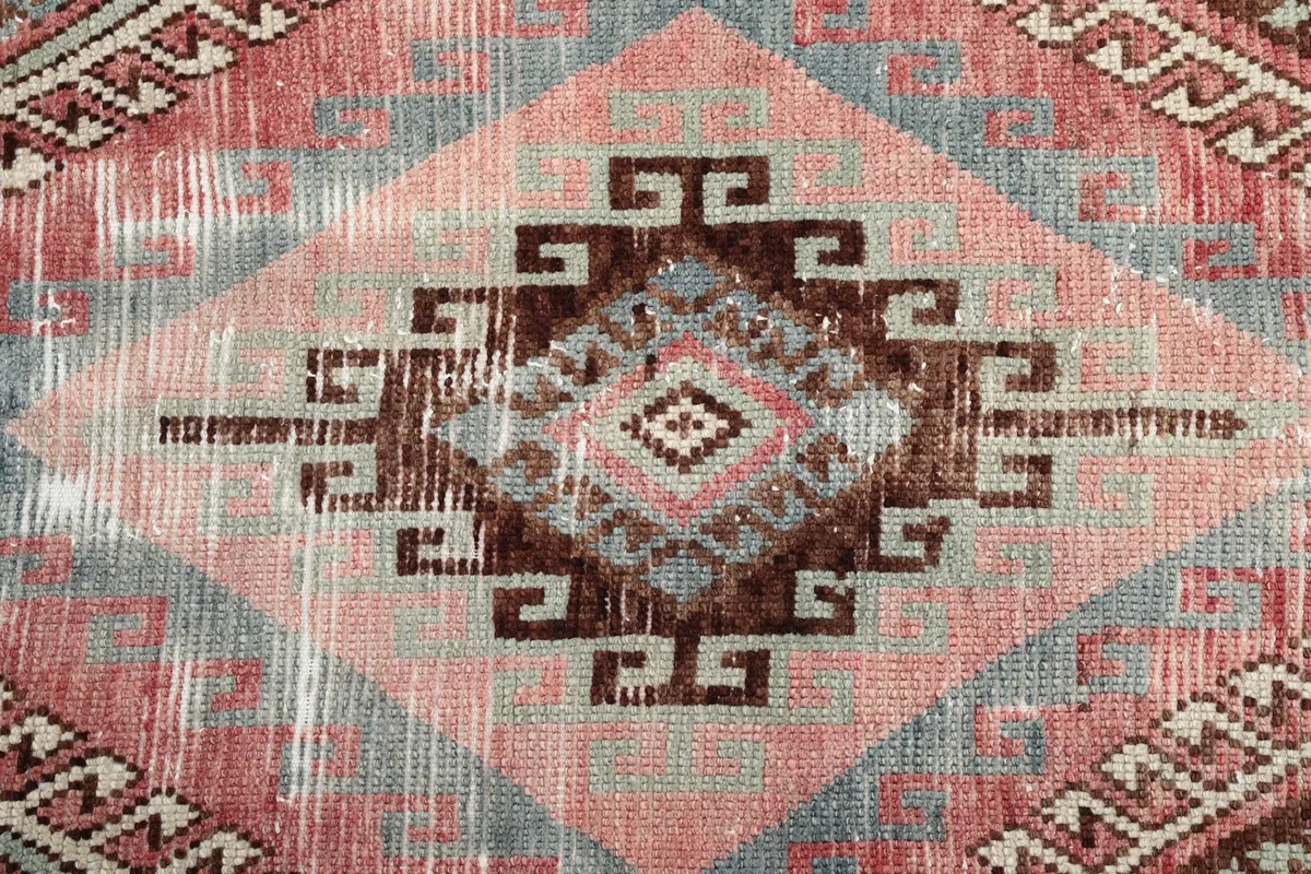 Close-up of a central brown and beige tribal diamond motif with fading