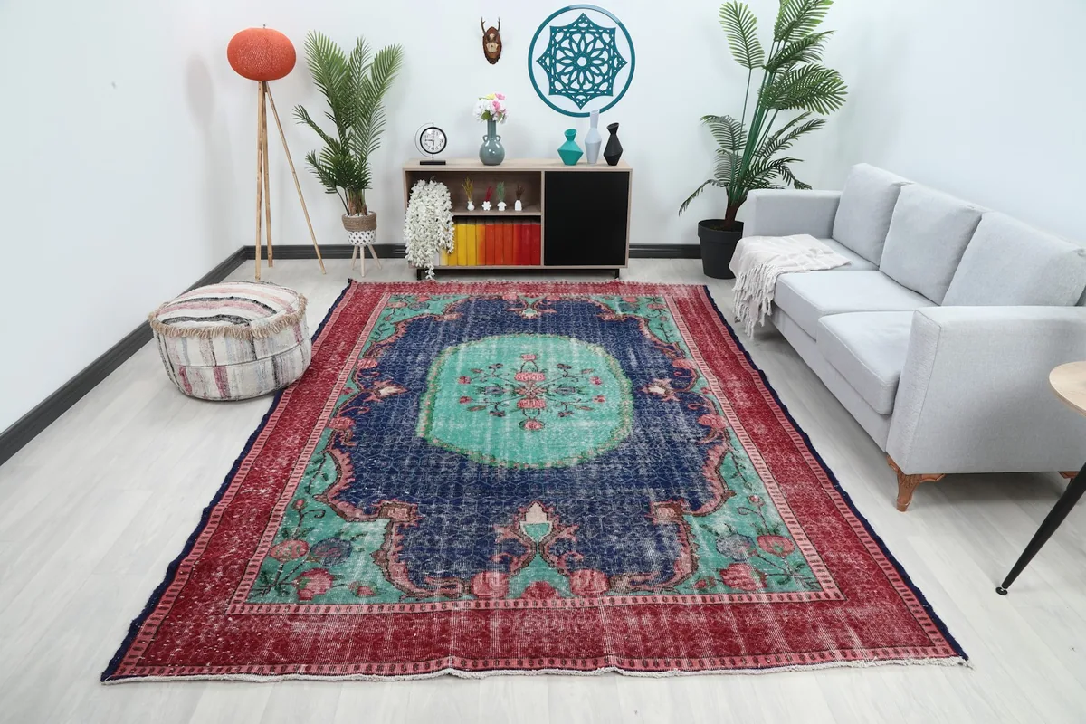 Large navy and red vintage rug in a living room setting with a light sofa