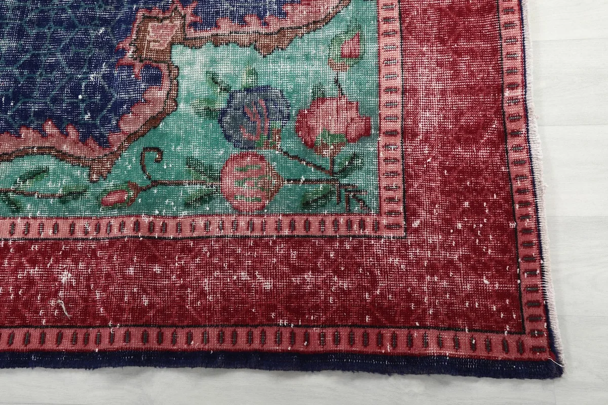 Close-up of the red border and a green corner motif of the rug