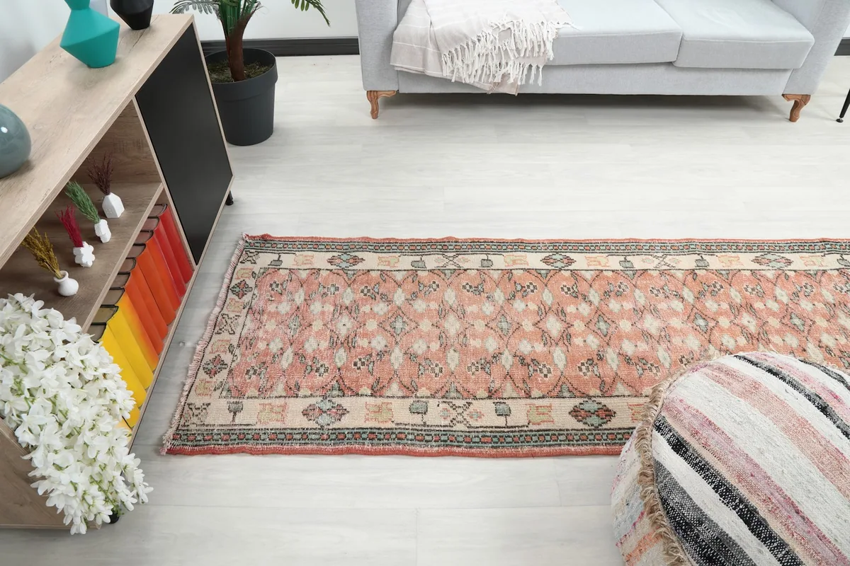 Wide shot of the rose runner rug extending through a room, viewed from a higher angle.