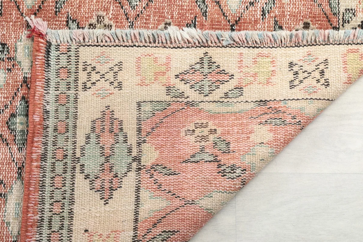 Close-up of the rug's end, showing the short fringes and the detailed border.