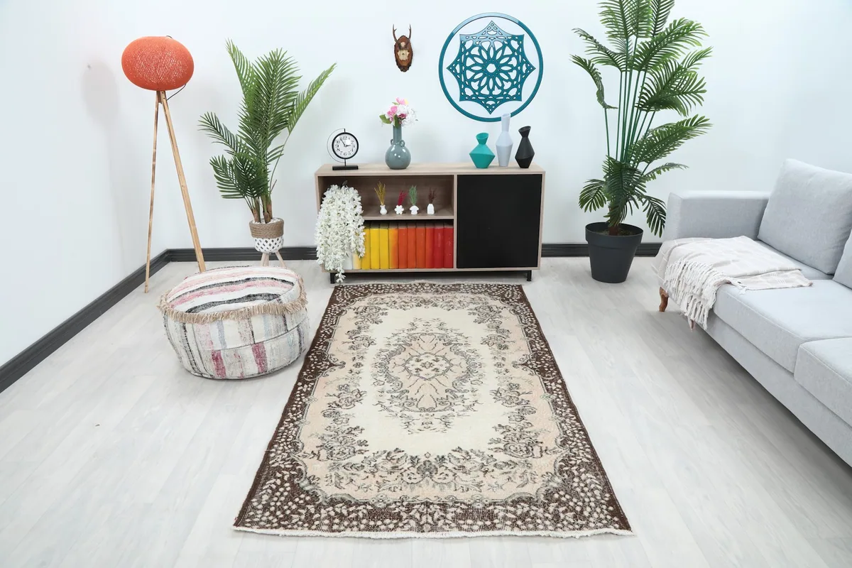 Vintage Anatolian rug displayed in a living room setting with a sofa and plants